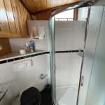 Photo de la salle de bain attenante à la cabine située à gauche. Elle comprend une douche spacieuse, des toilettes et un évier.
