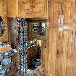 Photo du passage technique menant vers la cabine arrière du bateau. Il se situe dans la cuisine, la porte est symbolisée par un rideau.