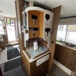 Photo du meuble de rangement haut et carré en bois situé dans la cuisine. Il sert à ranger les verres, les assiettes et les couverts.