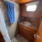 Image de la salle du bain du bateau composée d'une douche et d'une vasque