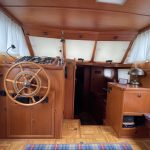 Image du poste de pilotage en bois du bateau.
