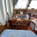 Photo du poste de pilotage en bois du bateau.