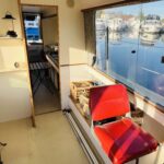 Jeanneau Eau Claire 930 river cruiser Cassis (1985) – saloon with red helm seat and galley