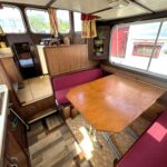 Locaboat 930 canal cruiser Sérénité (1981) – saloon with table and burgundy bench seats