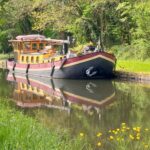 Dutch Hagenaar barge 18 m ANNA (1911) – exterior view on a tree-lined canal