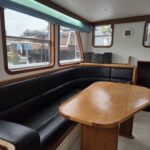 Bronsveen Kotter 1480 Dutch motor yacht Petit Michou (2002) – saloon corner settee and dining table