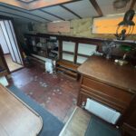 Dutch Tjalk sailing barge Osseo (1890) – saloon with writing desk and storage shelves