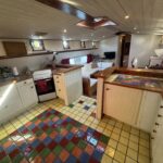Dutch Luxe-Motor barge Dulcinea (1929) – fitted galley with cooker and seating area beyond