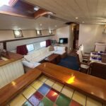 Dutch Luxe-Motor barge Dulcinea (1929) – saloon with corner sofa and dining area seen from the open galley