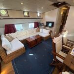 Dutch Luxe-Motor barge Dulcinea (1929) – saloon with large corner sofa, wooden coffee table and TV corner