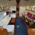 Dutch Luxe-Motor barge Dulcinea (1929) – saloon and dining area with white sofa and laid table
