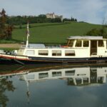 Dutch Luxe-Motor barge 14.50 m (1928) – exterior view on a canal below a castle