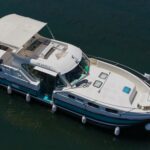 Nicols 1100 river cruiser Lodève (1998) – aerial port-side view, sun awning deployed