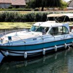 Nicols 1100 river cruiser Lodève (1998) – port-side view cruising on the canal