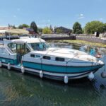 Nicols 1100 river cruiser Lodève (1998) – front three-quarter view on the canal, quay behind